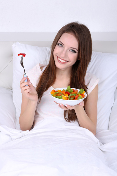 Young beautiful woman in bed with light breakfast  - 写真・画像