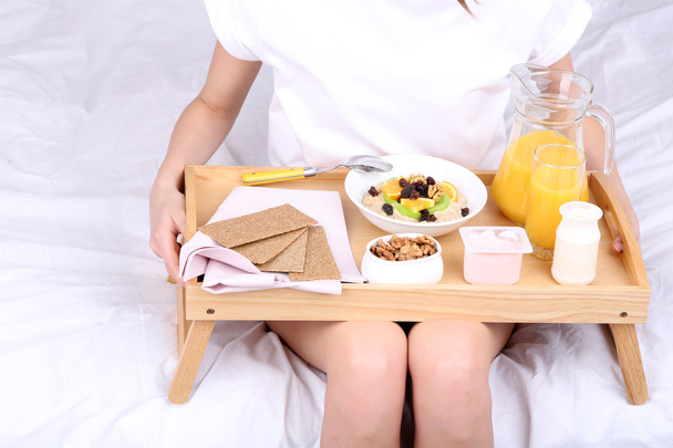 Young beautiful woman in bed with light breakfast  - Fotó, kép