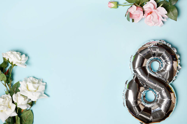 8 ezüst gombolyag virágokkal, kék háttérrel, fénymásoló felülettel. Női ünnep és március 8-i koncepció. üdvözlőlap - Fotó, kép