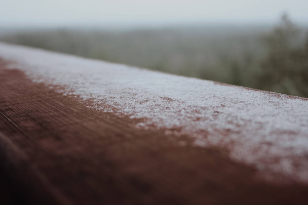 Nahaufnahme von Schnee auf dunkler Holzstruktur - Foto, Bild