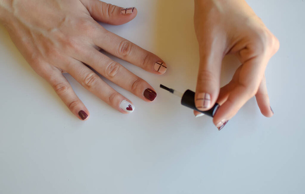 vrouwenhanden gebruiken de borstel om nagels te schilderen - Foto, afbeelding