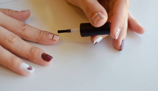 kobiece dłonie malują paznokcie pędzlem - Zdjęcie, obraz