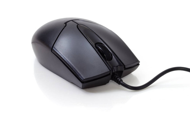 Preto mouse de computador óptico com fio típico com dois botões e roda de rolagem em uma superfície branca, close-up em foco seletivo - Foto, Imagem