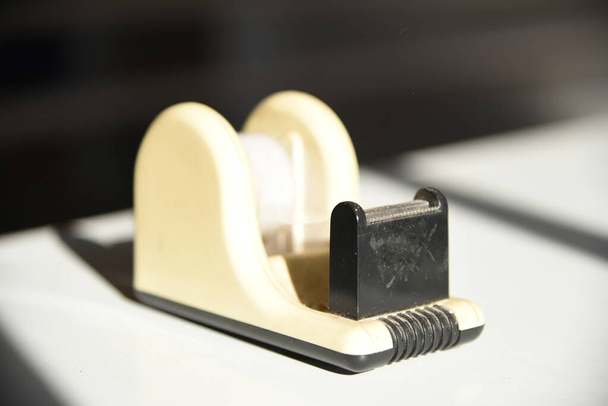 Tape Cutter Retro-Werkzeug auf dem weißen Schreibtisch mit Leerraum - Foto, Bild