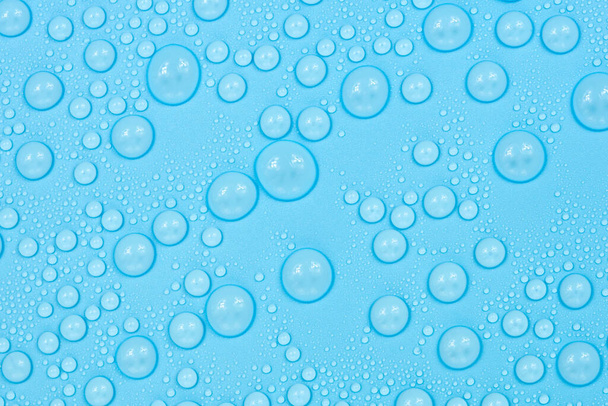 Gotas de agua sobre textura de fondo azul. Cristal de fondo cubierto con gotas de agua. burbujas en el agua - Foto, imagen