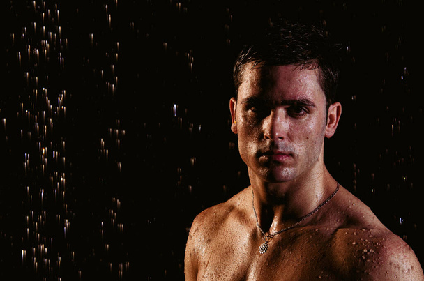 シャワーの下にハンサムな若い男が濡れ滴下. - 写真・画像