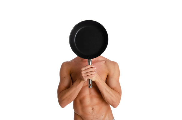 Σέξι shirtless νεαρός σεφ ή σερβιτόρος θέτουν, φορώντας μαύρη ποδιά σε γυμνό σώμα, απομονώνονται σε λευκό φόντο. - Φωτογραφία, εικόνα