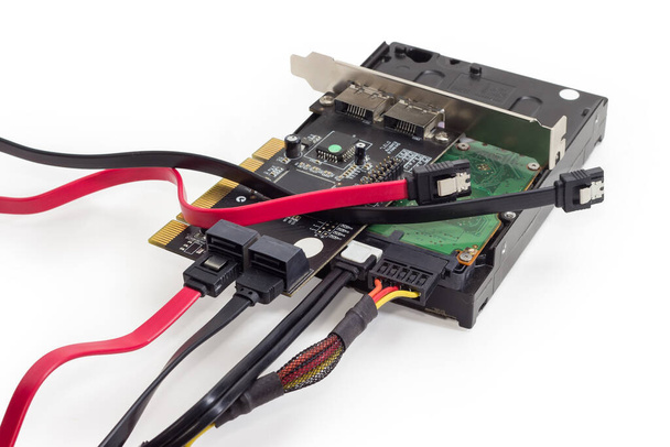 Жорсткий диск і карта контролера масиву дисків з підключеними кабелями, різними кабелями даних SATA, крупним планом на білому тлі
 - Фото, зображення