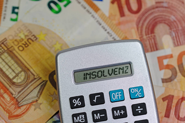 Calculadora de bolsillo con la palabra "Insolvencia", traducción "Insolvencia", en la pantalla - Foto, imagen