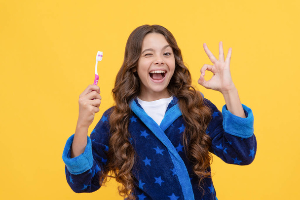 healthy beautiful smile. using best toothpaste. childrens stomatology. ok gesture. teen girl hold toothbrush. happy kid going to brush teeth. child in pajama do morning routine. dental care. - Photo, Image