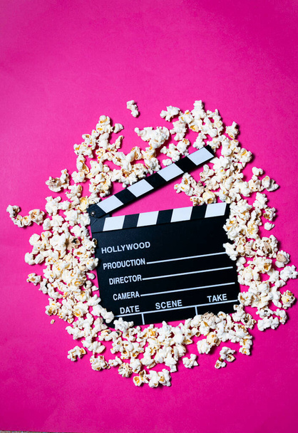 Elokuva clapperboard ja popcorn fuksia vaaleanpunainen tausta Käsite elokuva, viihde, audiovisuaalinen - Valokuva, kuva