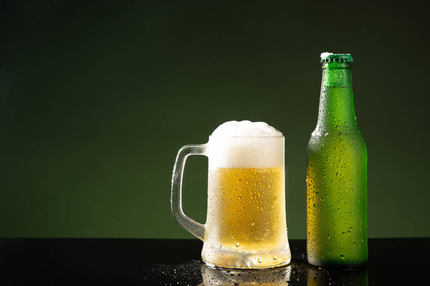 Tasse à bière et bouteille sur fond vert avec copyspace. - Photo, image
