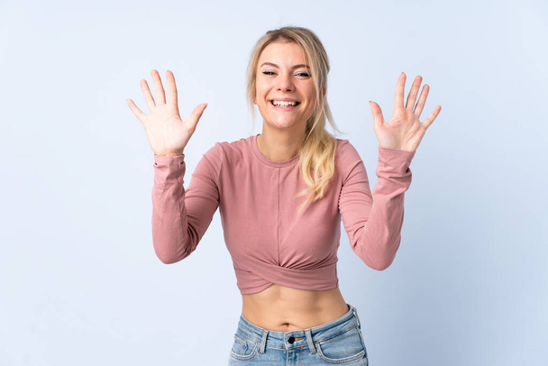 Blonde woman over isolated blue background counting ten with fingers - Фото, зображення