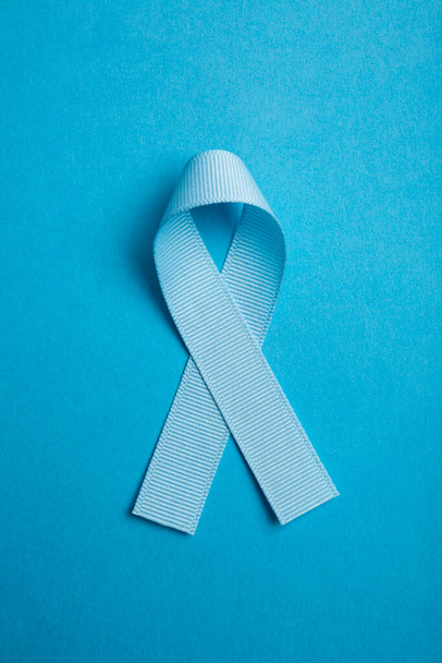 Modrá barevná stuha izolovaná na modrém pozadí. Symbol povědomí o rakovině prostaty. koncepce zdravotní péče a medicíny. Preventivní opatření. Zdraví mužů - Fotografie, Obrázek
