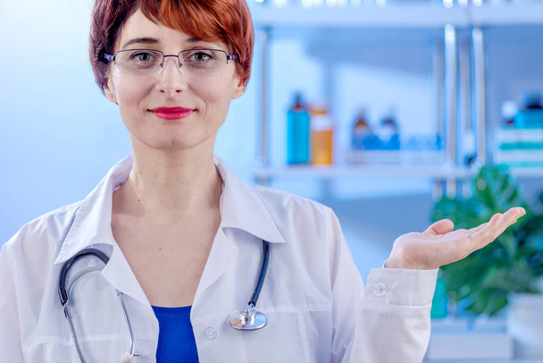 Kimenő női orvos elegáns rövid haj fehér orvosi kabát mutató kéz másolási hely szöveg - Fotó, kép