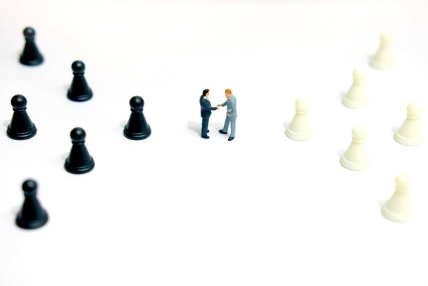 Concetto di business in miniatura - due uomini d'affari fanno un accordo di stretta di mano tra pedone degli scacchi - Foto, immagini