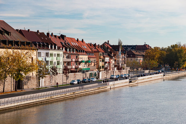 Würzburg, Blick auf den Main, moderne typisch deutsche Häuser stehen da, Menschen schlendern am Ufer entlang - Foto, Bild