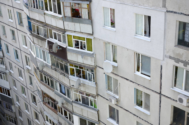 Voorzijde van een grijs, meervloers sovjetpaneelgebouw. Russische oude stedelijke woonhuizen met ramen en balkon. Typische Russische buurt - Foto, afbeelding