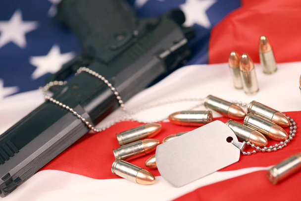 Wiele żółtych kul 9mm i pistolet z tagami na fladze Stanów Zjednoczonych. - Zdjęcie, obraz