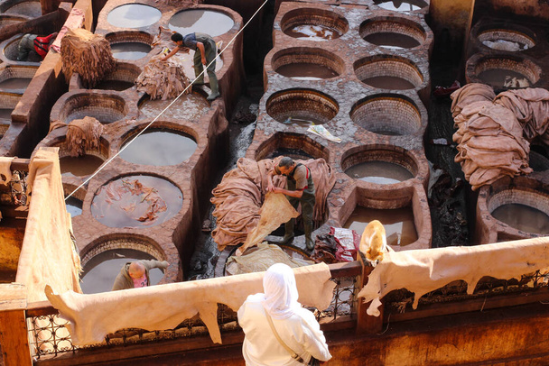 Вид сверху на процесс обработки и окраски шкур животных в каменные брезенты. Фес - Фото, изображение