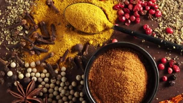 close up of various colorful spices rotating on wooden table top view - Footage, Video