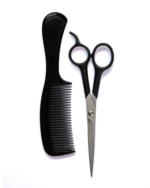 schwarzer Haarkamm und Schere zum Haare schneiden auf weißem Hintergrund - Foto, Bild