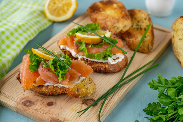 Bruschetta with smoked salmon, cream cheese, lettuce and chives - Photo, Image