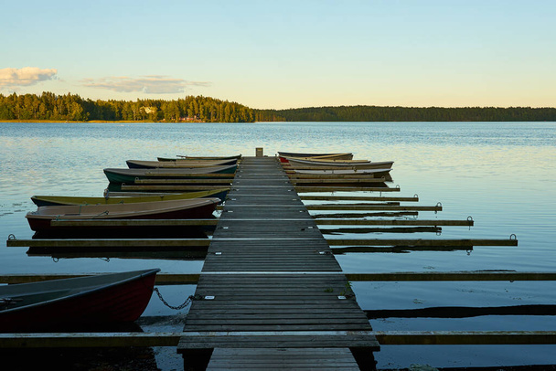   Bateaux amarrés sur la taupe du lac tranquille sur un coucher de soleil.                              - Photo, image