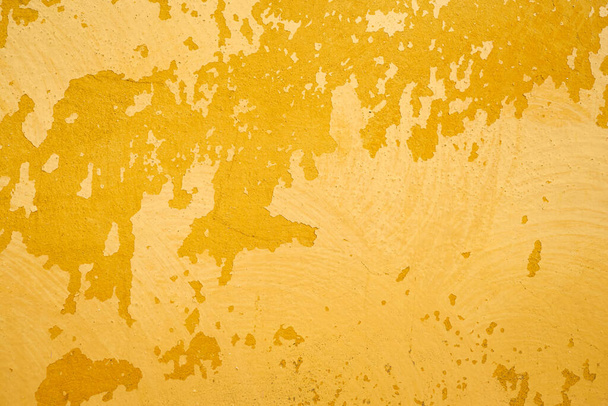 Mur jaune avec de la vieille peinture fissurée comme fond. - Photo, image