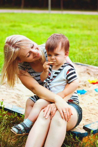 Szczęśliwej rodzinnej koncepcji. Matka i syn bawią się w parku i śmieją się podczas letniego spaceru w słoneczny dzień. Rodzinne wakacje i wspólnota, wybiórcze skupienie - Zdjęcie, obraz