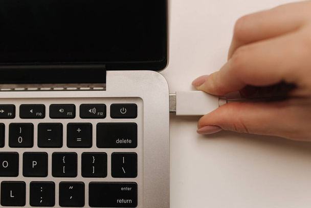 Femle käsi lisäämällä valkoinen USB-muistitikku tietokoneeseen kannettavan - Valokuva, kuva