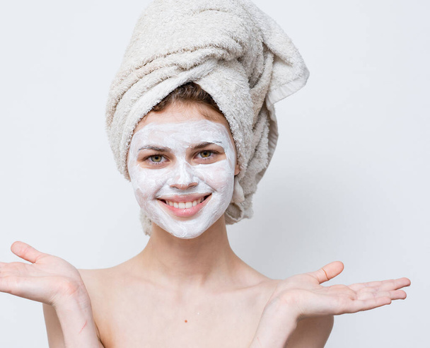 Kobieta w białej masce przeciwko czarnym kropkom na twarzy i ręczniku na głowie - Zdjęcie, obraz