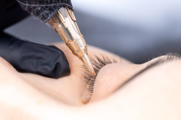 Contouring woman eye permanent make up tattoo black in beauty salon - Photo, Image