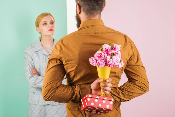 Valentinstag. Überraschung für Mädchen. Mann versteckt Blumen und Geschenk hinter dem Rücken. - Foto, Bild