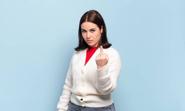 young pretty casual woman feeling angry, annoyed, rebellious and aggressive, flipping the middle finger, fighting back - Foto, Imagem