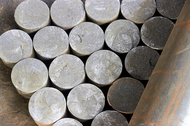 Hintergrund aus runden Metallbarren, die in der Werkstatt geschnitten wurden - Foto, Bild