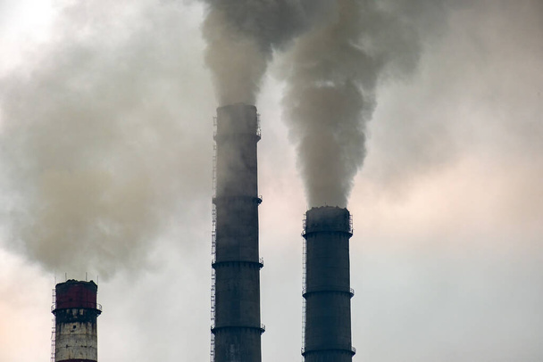 Planta de carbón tuberías altas con humo negro subiendo por la atmósfera contaminante. - Foto, Imagen
