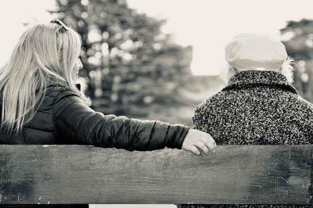 Eine ältere, 90-jährige Frau genießt die Zeit mit ihrer Tochter in einem örtlichen Park. Ihre Demenz und ihre gesundheitlichen Probleme bedeuten, dass sie nur wenige derartige Gelegenheiten hatte, während sie sich während des Lockouts abschirmte.  - Foto, Bild