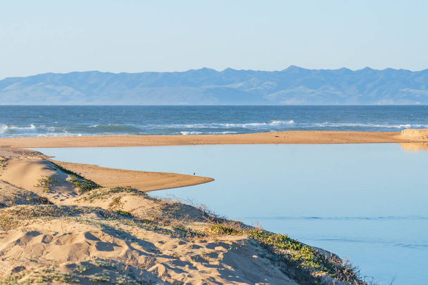 Piękny krajobraz morski. Błękitny ocean, niebieska rzeka, sylwetka gór i wydmy, California Central Coast - Zdjęcie, obraz