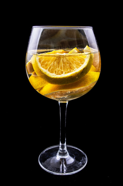 Orange slices on a glass on wine with dark background - Photo, image