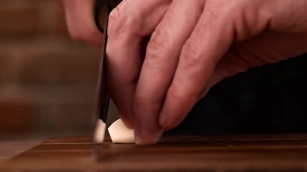 Fastly chopping garlic cloves on a wooden board. - Footage, Video