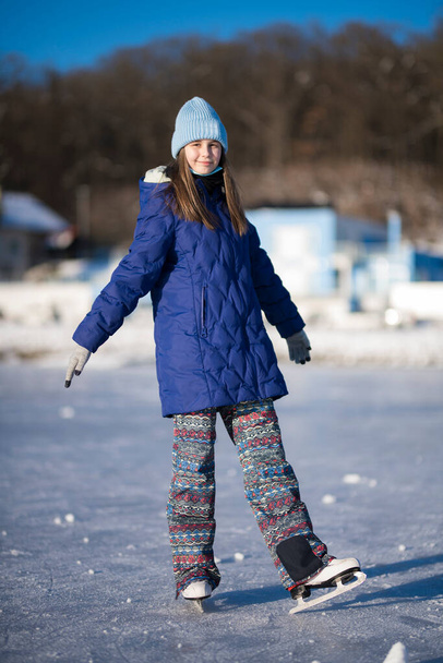 Inverno menina patinação no gelo se divertindo na pista de patinação no gelo ao ar livre.  - Foto, Imagem