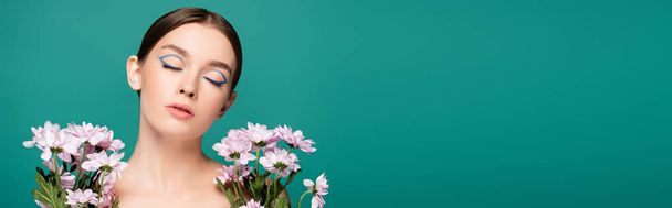 pretty young woman posing with closed eyes near pink flowers isolated on green, banner - Photo, Image
