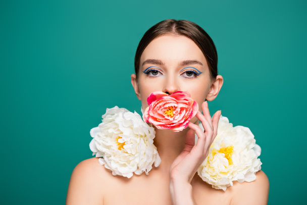 young woman with fresh peonies looking at camera isolated on green - Foto, Imagem