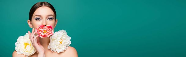 charming young woman with fresh peonies looking at camera isolated on green, banner - Photo, Image