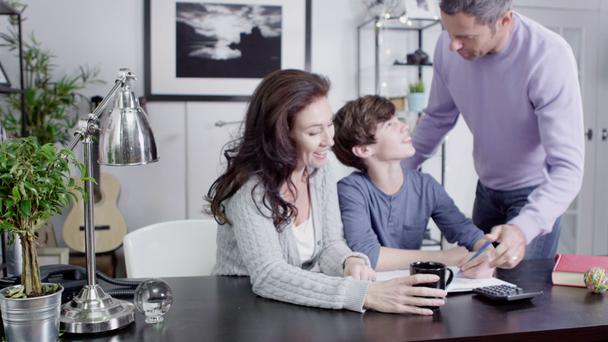 attraktives Paar hilft seinem Sohn bei den Hausaufgaben - Filmmaterial, Video