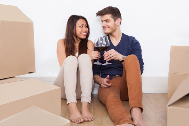 Couple Toasting Wineglasses In New Home - 写真・画像