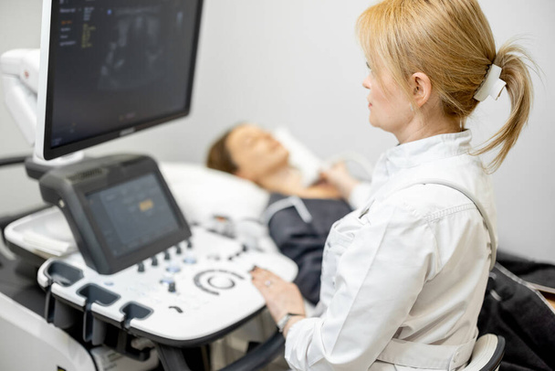 Arzt untersucht Schilddrüse von Patientin mit Ultraschall in Klinik - Foto, Bild