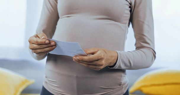 Καλλιεργημένη άποψη της εγκύου γυναίκα κρατώντας υπερηχογράφημα του μωρού  - Φωτογραφία, εικόνα