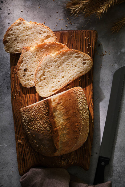 Zanaatkar bir sepette kızarmış ekmek dilimledi. Gri arka planda basit bir kahvaltı. Yakın çekim görünümü - Fotoğraf, Görsel